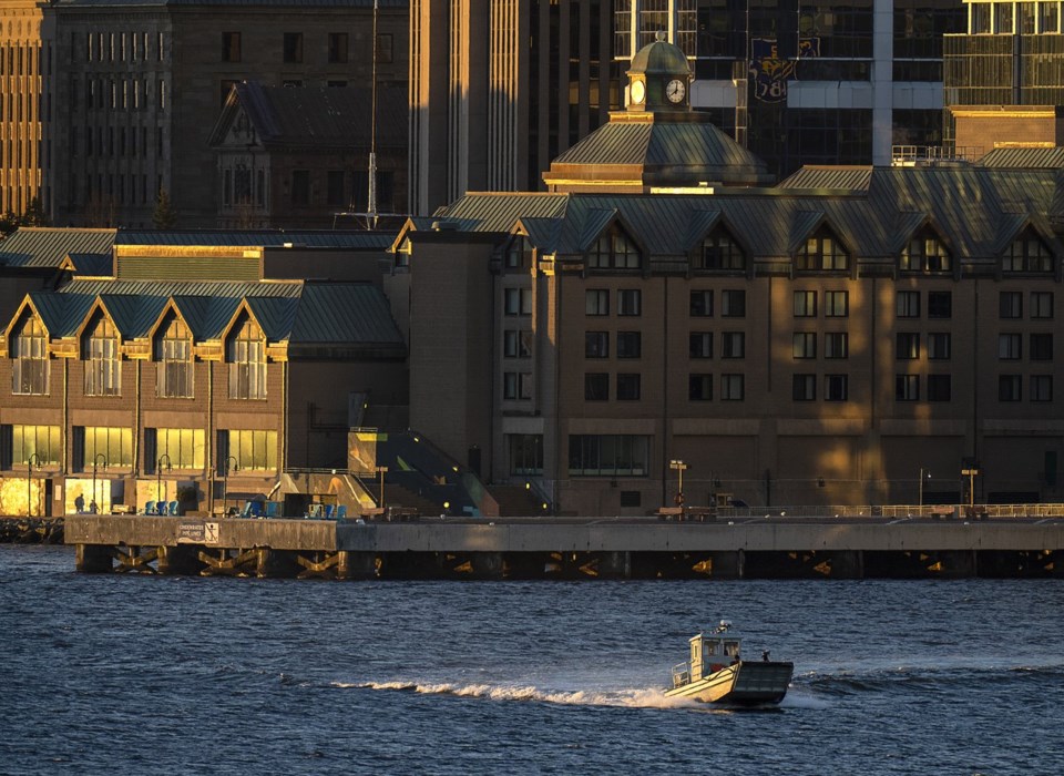 Boat crossing Halifax Harbour in front of waterfront buildings